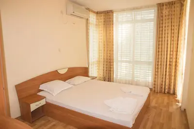 a small bedroom with a bed and a window at Elite Apartments in Sunny Beach