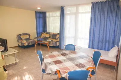a living room with a table and chairs and a couch at Elite Apartments in Sunny Beach