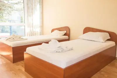 two twin beds in a room with a window at Elite Apartments in Sunny Beach