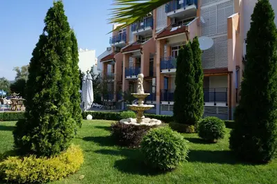 a park in front of a building with a fountain at Elite Apartments in Sunny Beach