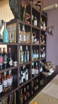 a shelf filled with lots of bottles of alcohol at Hotel Diamanti in Sozopol
