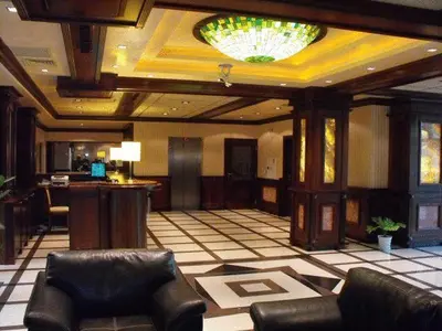 a lobby with leather chairs and a chandelier at Hotel Park in Karnobat