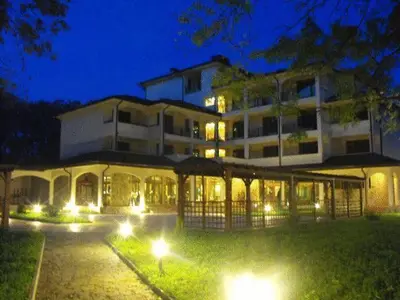 a large building with lights in front of it at night at Hotel Park in Karnobat