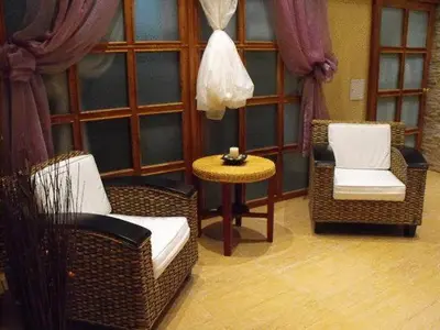 a living room with wicker chairs and a table at Hotel Park in Karnobat