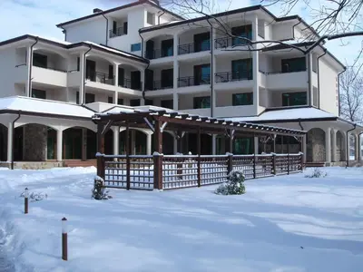 a large building with a fence in the snow at Hotel Park in Karnobat