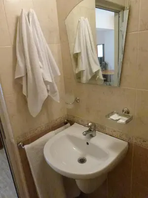 a bathroom with a sink and a mirror and towels at Hotel Beroe in Sveti Vlas