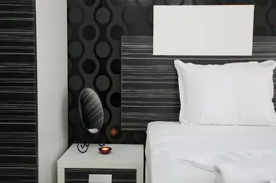 a bedroom with a white bed and a black headboard at Hotel Rainbow 3 Resort Club in Sunny Beach