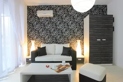 a living room with a couch and a black and white wall at Hotel Rainbow 3 Resort Club in Sunny Beach