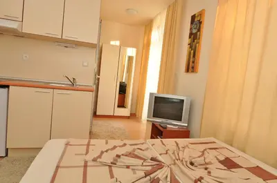 a living room with a kitchen and a television at Rainbow 2 Holiday Complex in Sunny Beach