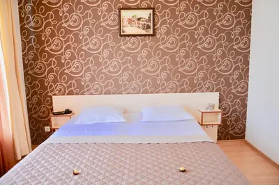 a bedroom with a bed and a wall with a wallpaper at Rainbow 2 Holiday Complex in Sunny Beach