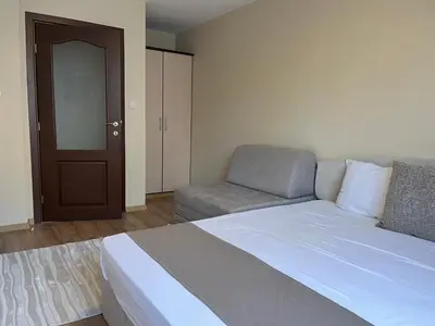 a bedroom with a bed and a couch and a door at Hotel Silver in Sozopol