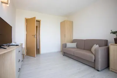 a living room with a couch and a television at Hotel Coop - Kiten in Kiten