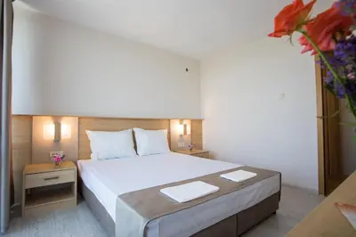 a bedroom with a large bed with white sheets at Hotel Coop - Kiten in Kiten