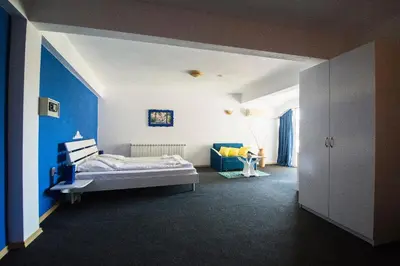 a bedroom with a bed and a blue wall at Family Hotel Four Seasons Tsarevo in Tsarevo