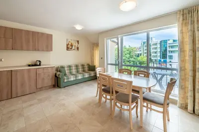 a kitchen and dining room with a table and a window at Perla Apartments in Nesebar