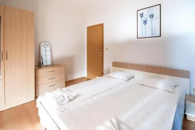a bedroom with a large white bed and a cabinet at The chill House in Sunny Beach in Sunny Beach