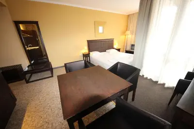 a hotel room with a bed and a table and chairs at Menada Apartments in Royal Beach in Sunny Beach