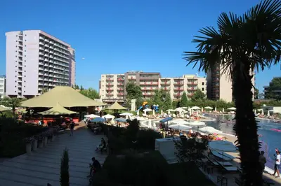 a resort with tables and umbrellas and a pool at Menada Apartments in Royal Beach in Sunny Beach