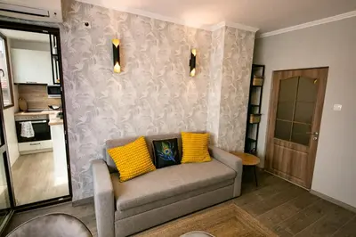 a living room with a couch with two yellow pillows at Cathedral Apartment Varna in Varna City