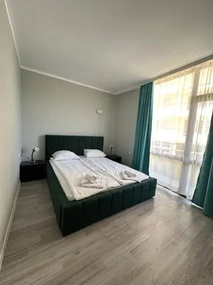 a bedroom with a large bed and a large window at Complex Sands Holiday Apartments in Sunny Beach
