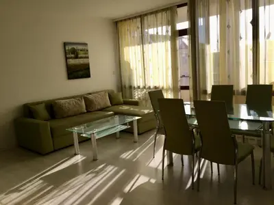 a living room with a couch and a table and chairs at Complex Sands Holiday Apartments in Sunny Beach