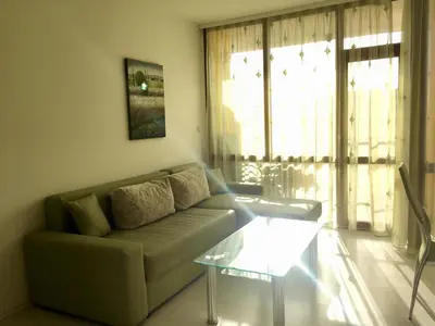 a living room with a couch and a glass table at Complex Sands Holiday Apartments in Sunny Beach