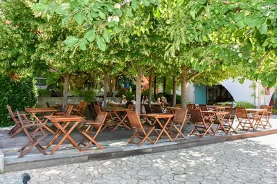 a group of tables and chairs under trees at Visit Sunny Beach Marina Apartments in Ravda