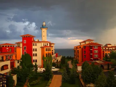 a group of buildings with a lighthouse in the background at Visit Sunny Beach Marina Apartments in Ravda