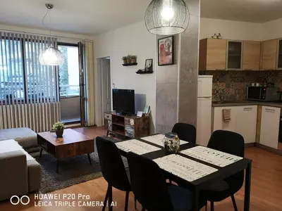 a living room with a dining table and a kitchen at Sea Garden Apartment IDM in Varna City