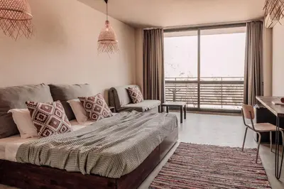 a bedroom with a bed and a living room with a window at Sunny Beach Club - Adults Only #YouthfulVibes in Sunny Beach