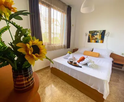 a bedroom with a bed with a vase of flowers at Apartments Yana in Obzor