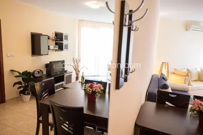 a dining room and living room with a table and chairs at Complex Apolon in Nesebar