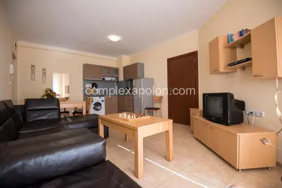 a living room with a black leather couch and a table at Complex Apolon in Nesebar