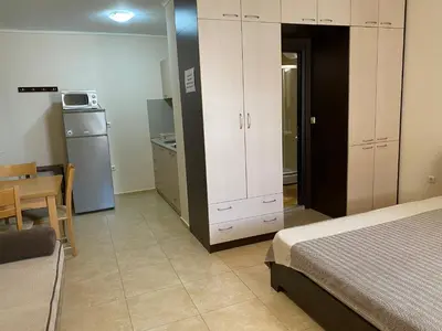a bedroom with a bed and a table and a kitchen at Complex Apolon in Nesebar