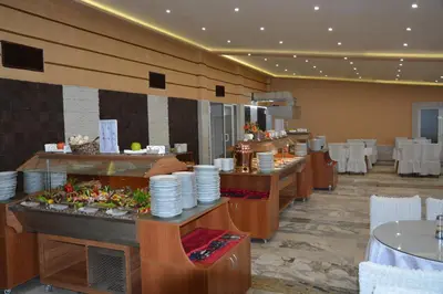 a restaurant with a buffet line with plates on display at Hotel Neva in Kiten