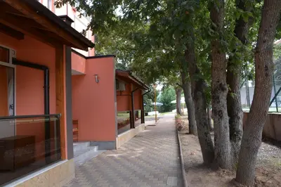 a sidewalk with trees next to a building at Hotel Neva in Kiten