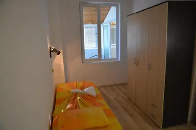 a room with a bed with a gift on it at Hotel Neva in Kiten