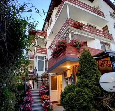 a white building with flower boxes on the balconies at Guesthouse Oasis in Kiten