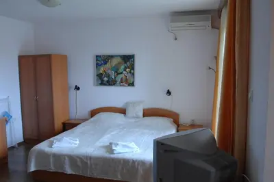 a bedroom with a bed with a tv in it at Condo Hotel Valentina in Obzor