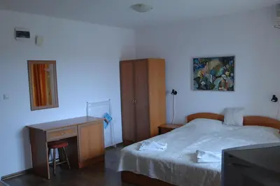 a bedroom with a bed and a desk and a television at Condo Hotel Valentina in Obzor