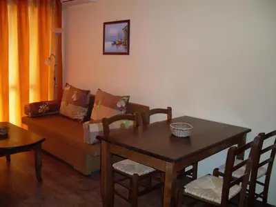 a living room with a couch and a table with chairs at Condo Hotel Valentina in Obzor