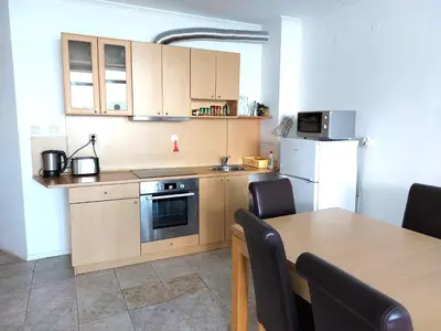 a kitchen with a table and a stove and a refrigerator at Vega Village Ap B39 in Sveti Vlas