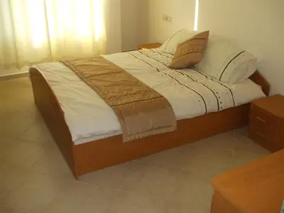 a bed with white sheets and pillows on it at Samara Apartment in Lozenets