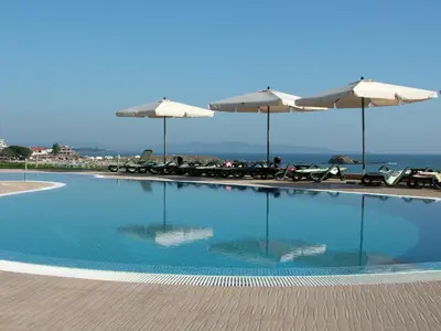 a swimming pool with chairs and umbrellas at Samara Apartment in Lozenets