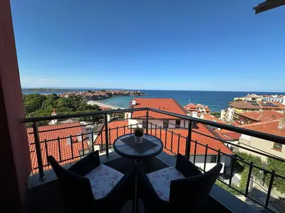 a balcony with a table and chairs and the ocean at Family Hotel Radiana in Sozopol