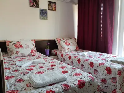 a bedroom with two beds with red and white sheets at Family Aparthotel Vintegra in Burgas City