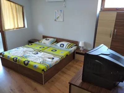 a small bedroom with a bed and a television at Guest House Niya Chernomorets in Chernomorets