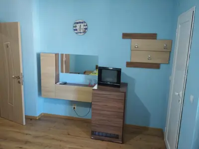 a room with a tv on a stand with a mirror at Guest House Niya Chernomorets in Chernomorets