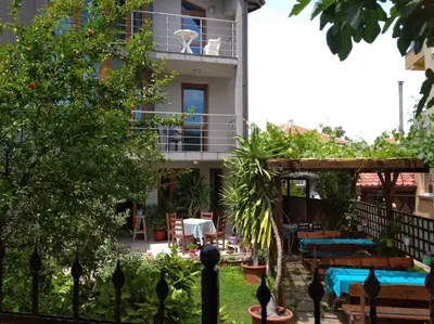 a building with a balcony with tables and chairs at Guest House Niya Chernomorets in Chernomorets
