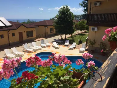 a view of a swimming pool with chairs and flowers at Complex Terazini in Byala